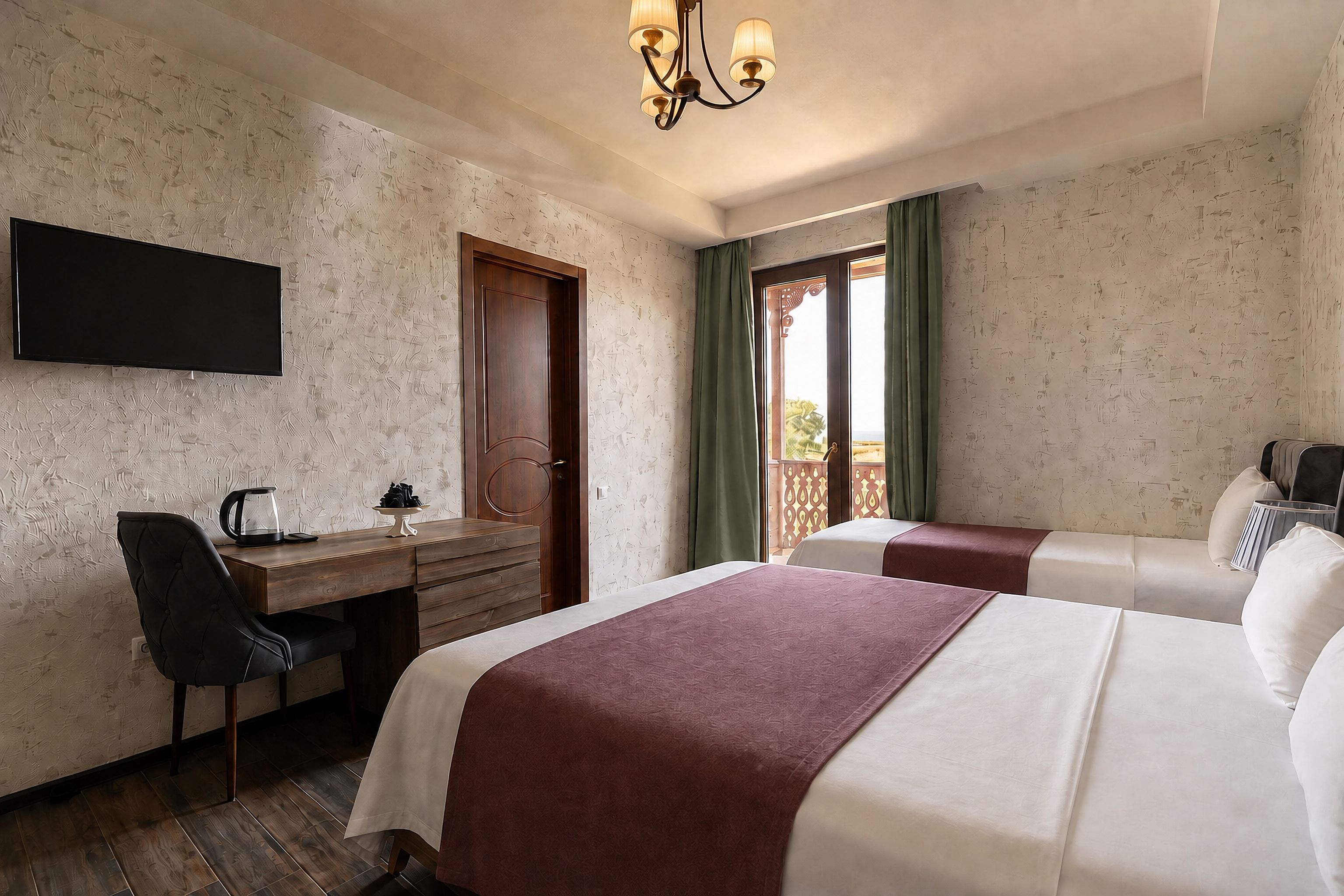 A hotel room with a bed, a desk, a chair, a television, and a window with curtains.