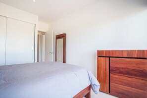 Ein Schlafzimmer mit einem Bett, einem Holz-Kopfteil und einem Kleiderschrank.