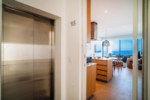 Un intérieur moderne comprenant un espace cuisine, un coin repas et une vue sur l’océan.
