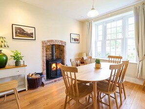 A cozy room with a fireplace, wooden furniture, and a large window. - Dolhiryd (Llangollen)