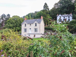 A two-story house with a symmetrical facade, a central entrance, and a small porch. - Dolhiryd (Llangollen)