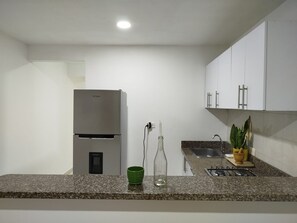 A modern kitchen with a built-in refrigerator, a sink, and a stove. - Just two blocks from San Felipe Castle! A cozy and warm apartment (Cartagena de Indias)