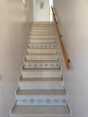 A staircase with patterned tiles and a wooden handrail. - Apartment 'La Salamandre' with Mountain View, Wi-Fi and Air Conditioning (Villelongue-dels-Monts)