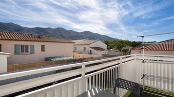 A residential area with houses, a white fence, and a table with a chair.