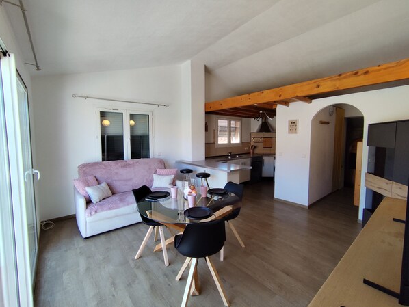 A modern living space with a dining area, kitchenette, and a cozy seating area. - Apartment 'La Salamandre' with Mountain View, Wi-Fi and Air Conditioning (Villelongue-dels-Monts)