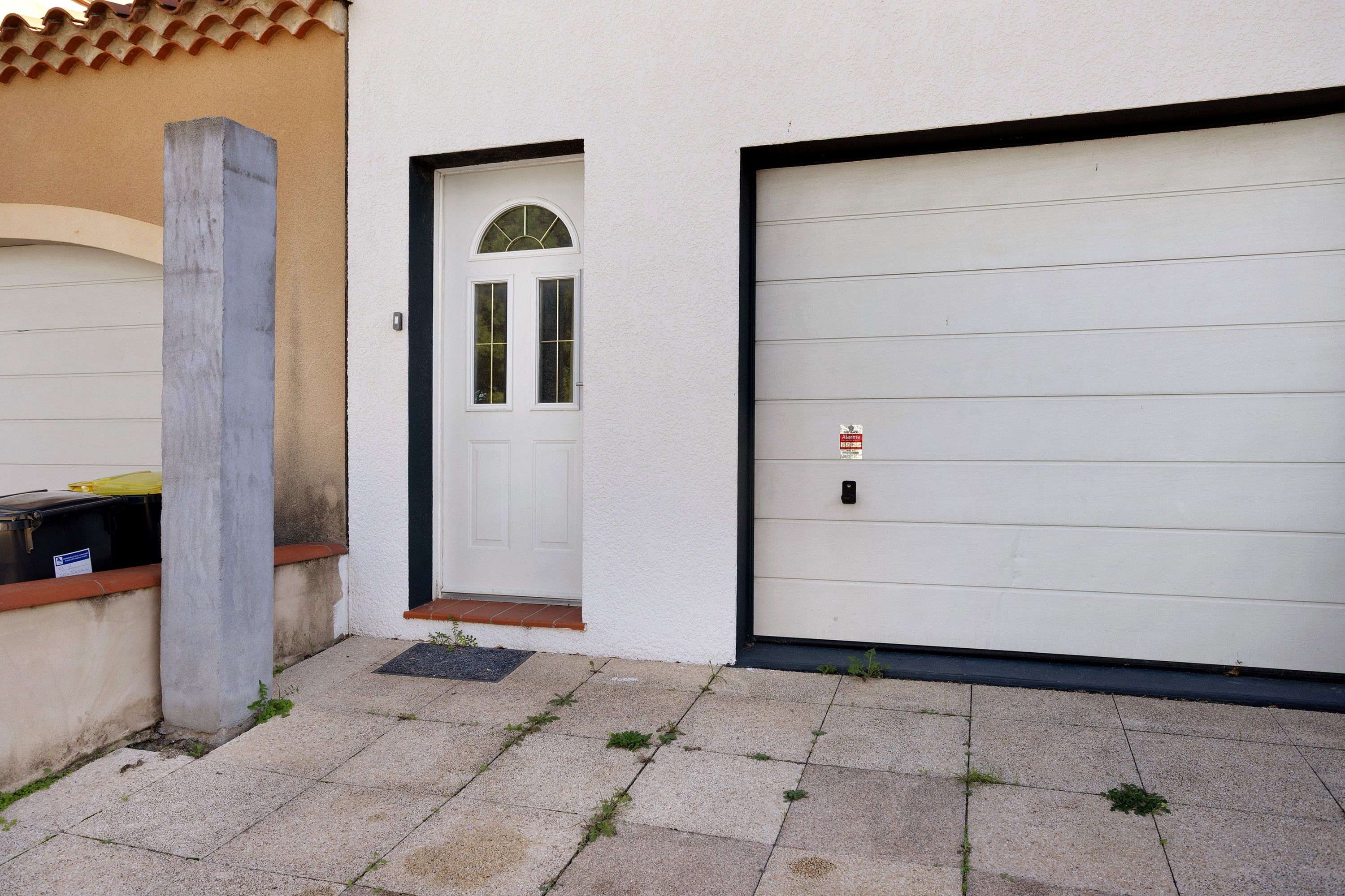 Eine Garage mit einer weißen Tür und einem Garagentor.