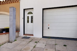 A residential garage with a white door and a garage door.