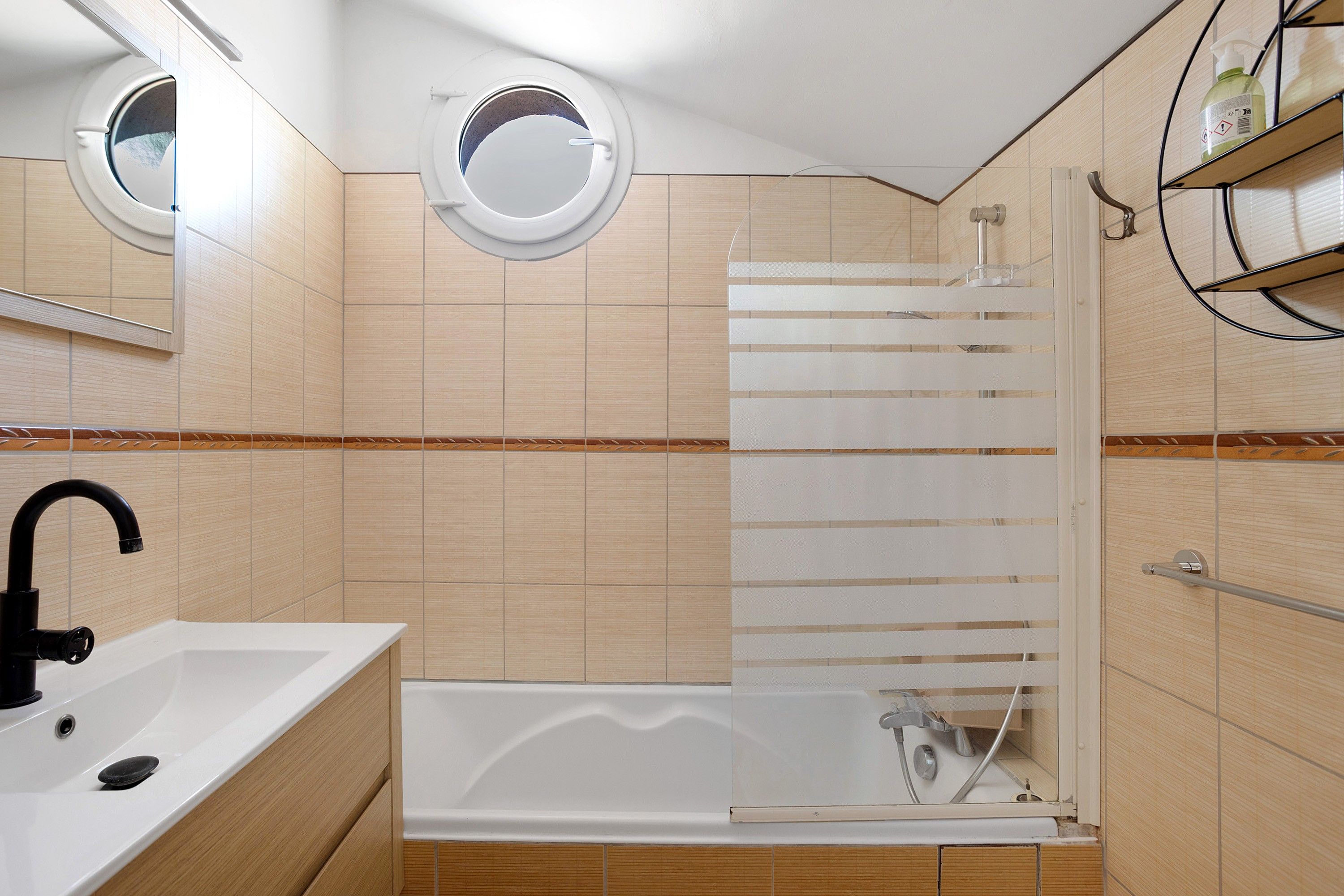 A modern bathroom with a bathtub, a shower enclosure, and a sink.