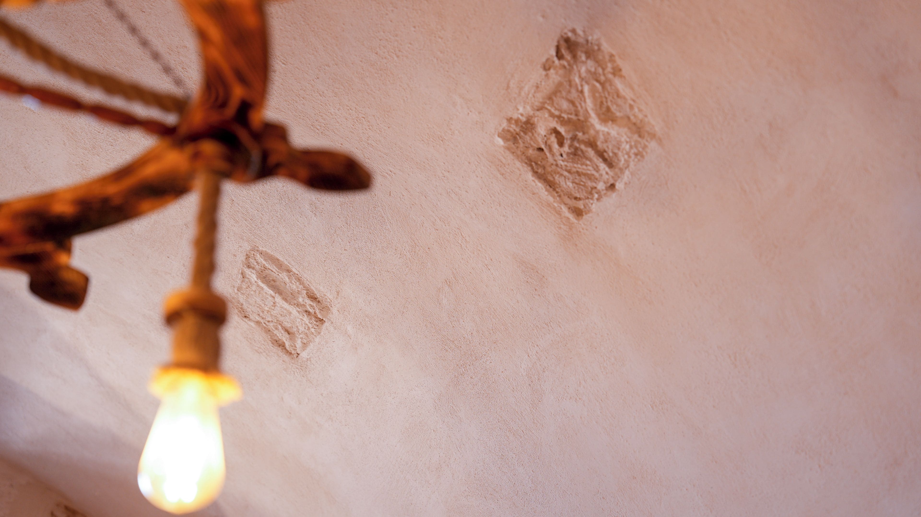 A ceiling with a light fixture and two visible marks or stains.