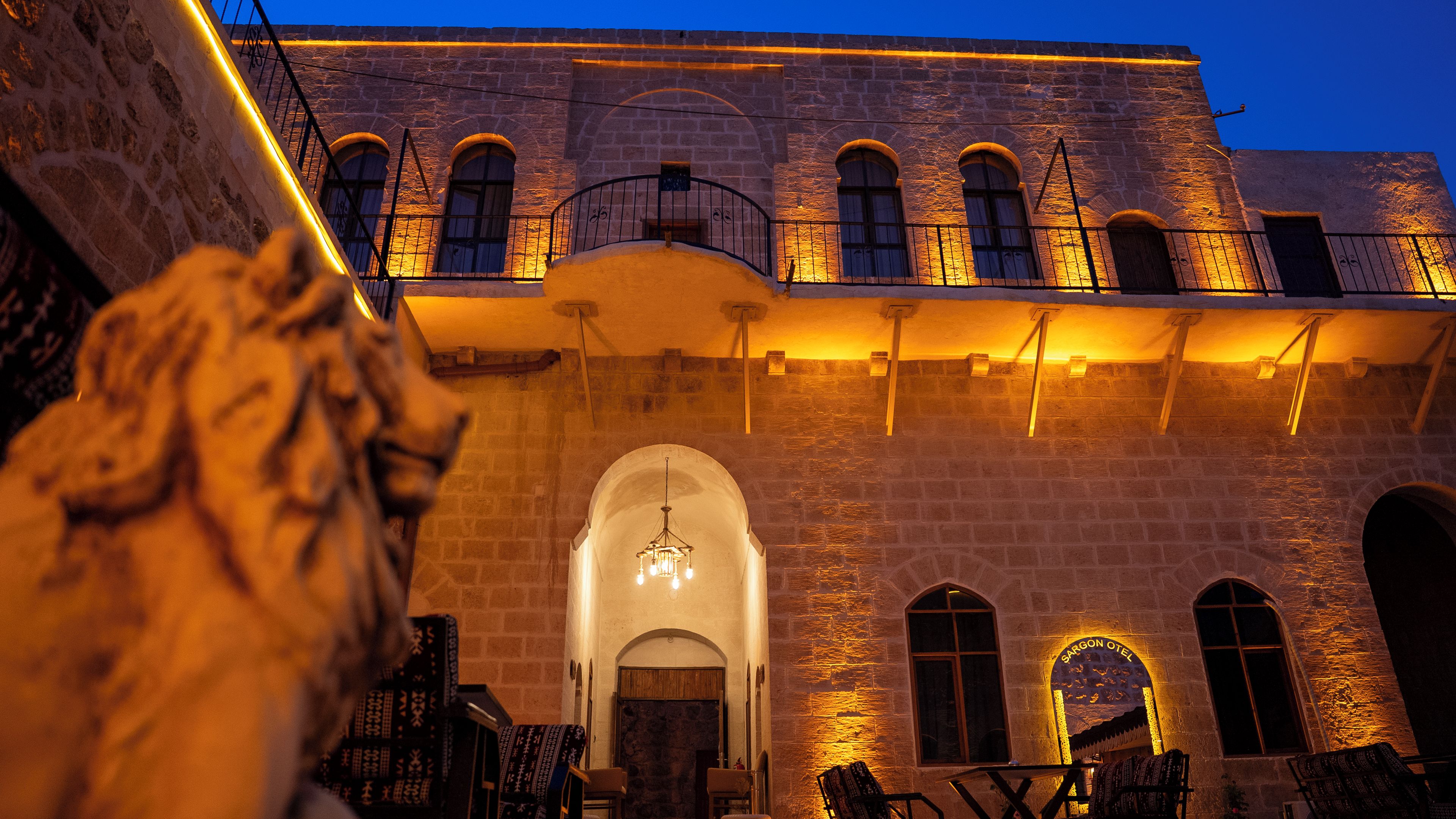 Um edifício de pedra com janelas em arco e uma escadaria que leva a uma varanda.