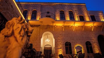 Um edifício de pedra com janelas em arco e uma escadaria que leva a uma varanda.