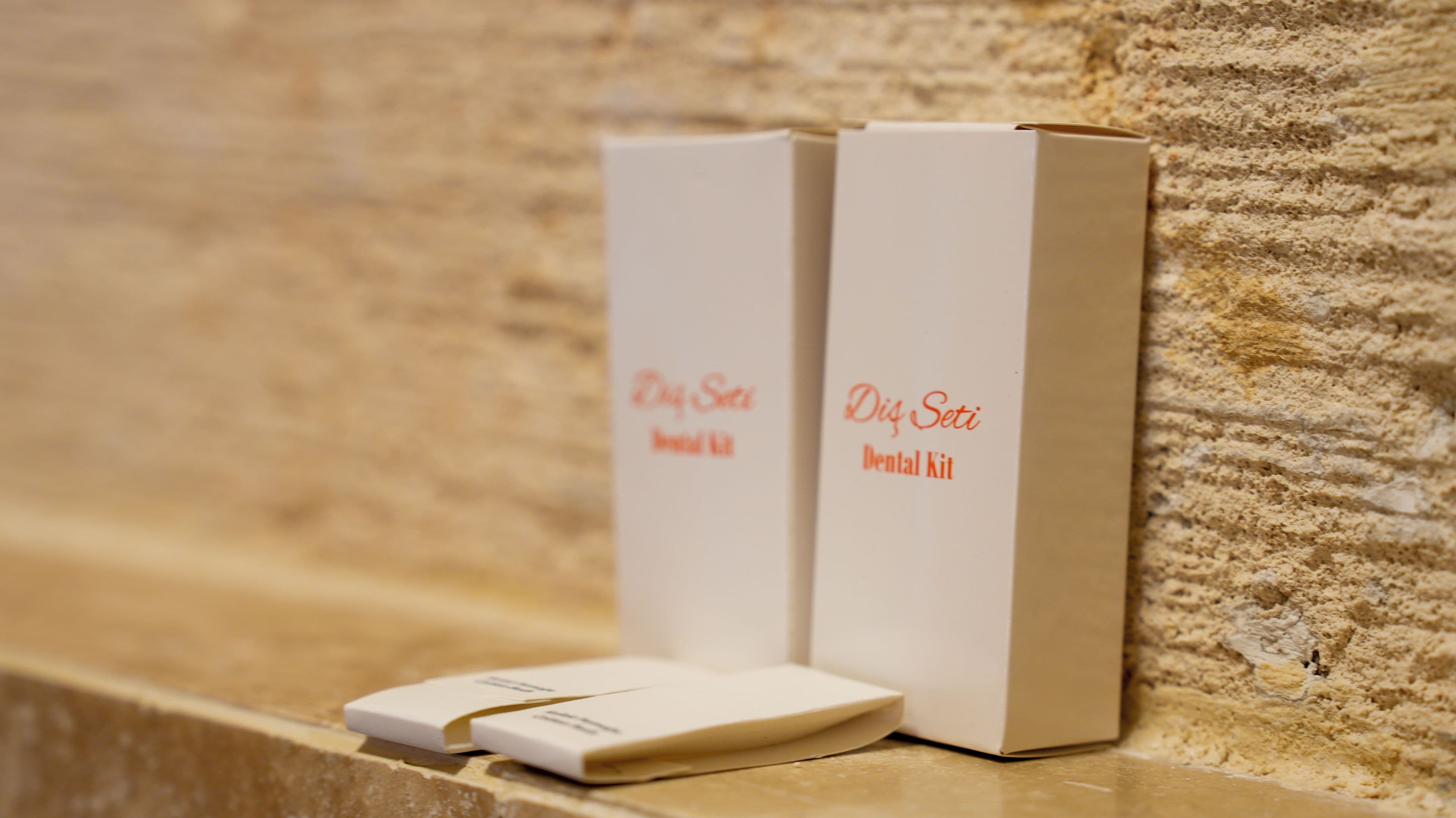 Two white boxes labeled 'Dry Sea Dental Kit' on a textured stone surface.