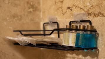 Uno scaffale in bagno con articoli da toilette, tra cui bottiglie e un sacchetto di plastica.