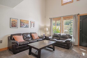 A living room with a sectional sofa, a coffee table, and two framed landscape paintings on the wall. - Walk to Ski Lifts | 2 Living Areas | Sleeps 8 (Brian Head)