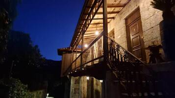 Un bâtiment doté d’un espace extérieur abrité, d’un escalier et d’un mur en pierre.