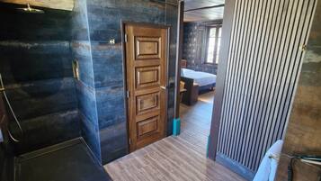 Une pièce avec une porte en bois, une baignoire et un espace douche.