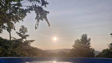 On aperçoit clairement une piscine dont l’eau, calme et limpide, reflète le ciel.