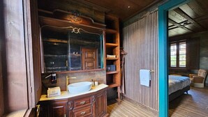 A wooden bathroom with a large mirror, a sink, and a towel hanging on the wall. - Deluxe Three-Bedroom Vila 3 Bathrooms, incl Breakfast (Jugueiros)