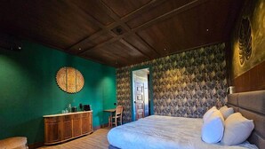 A bedroom with a large bed, a wooden headboard, a green wall, a patterned wallpaper, and a wooden cabinet. - Deluxe Three-Bedroom Vila 3 Bathrooms, incl Breakfast (Jugueiros)