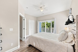 A bedroom with a bed, a ceiling fan, a window with curtains, and a view of greenery outside. - Murrells inlet Peeps (Murrells Inlet)