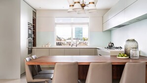 Una cocina moderna con una isla central, electrodomésticos de acero inoxidable y vistas a la ciudad.