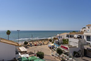 A coastal town with a beach, buildings, and a clear sky. - #424 Sea View | 3BR & Balcony | Olhos de Água (Albufeira)