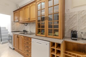 A kitchen with wooden cabinets, a dishwasher, a stove, and a coffee maker. - #424 Sea View | 3BR & Balcony | Olhos de Água (Albufeira)