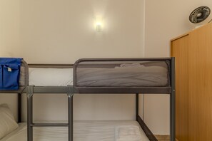 Una cama litera con cabecera de malla, una bolsa azul en la parte superior y una toalla blanca en la inferior.