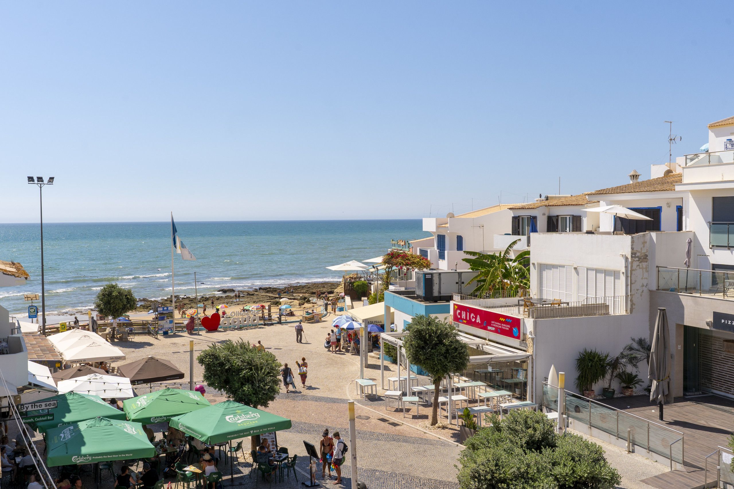 Une ville côtière dotée d’une plage, de terrasses et offrant une vue sur la mer.