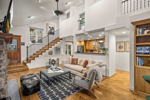 A spacious living area with a staircase, a kitchen, and a bookshelf. - Abode on Norfolk, Old Town PC home, hot tub, walk to Town Lift (Park City)