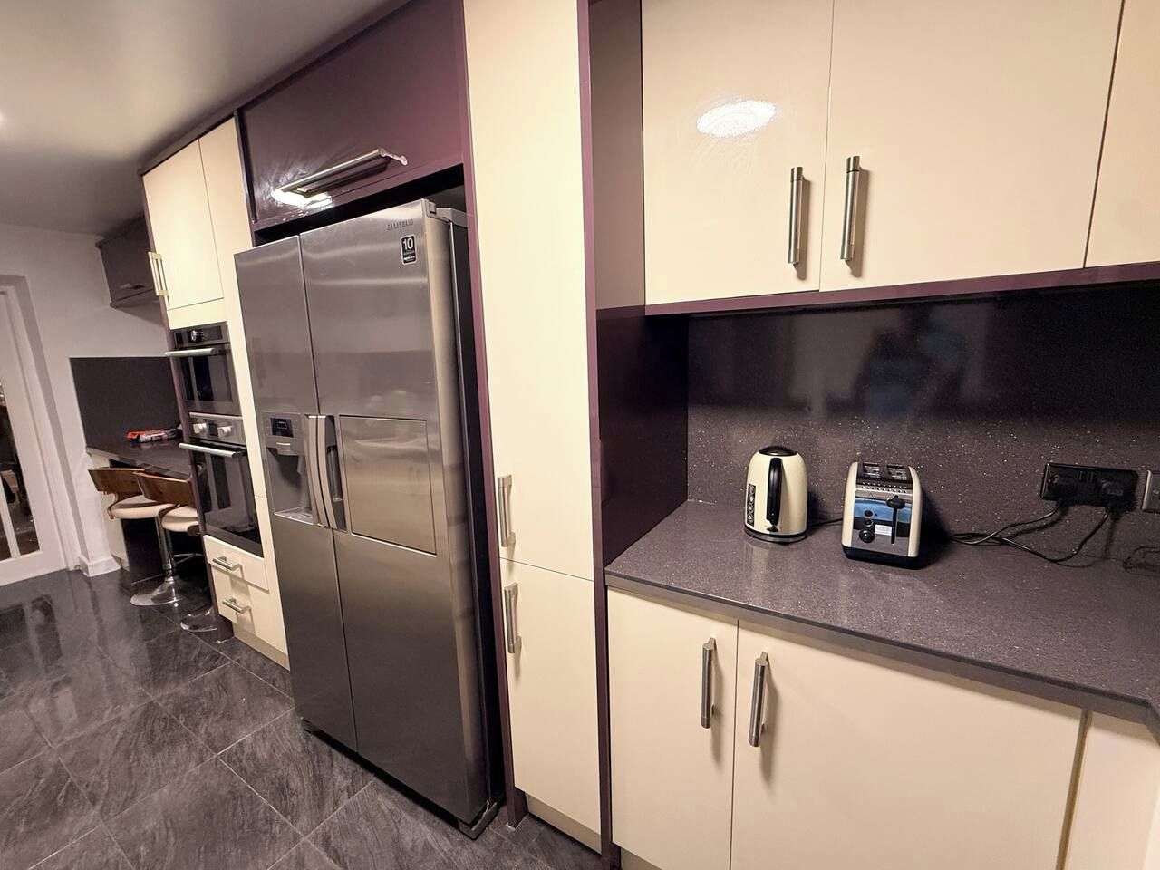 Een moderne keuken met roestvrijstalen apparatuur, een inbouwoven en een broodrooster op het aanrecht.