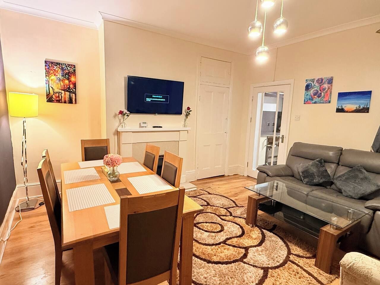 Ein modernes Wohnzimmer mit Esstisch, Sofa und Fernseher.