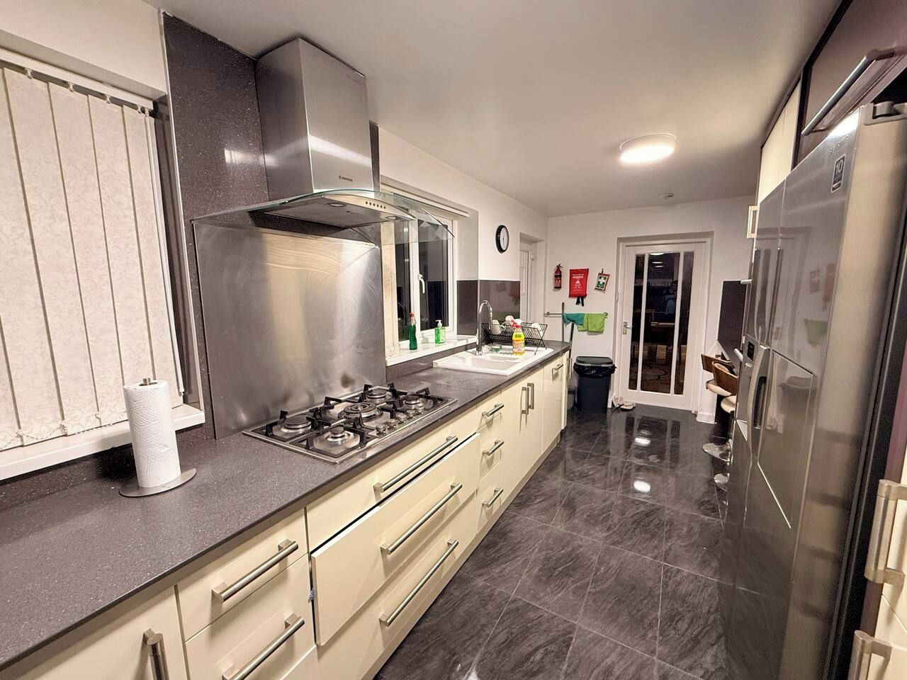 A modern kitchen with stainless steel appliances, a gas stove, and a large refrigerator.