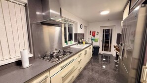 Eine moderne Küche mit Edelstahlgeräten, einem Gasherd und einem großen Kühlschrank.