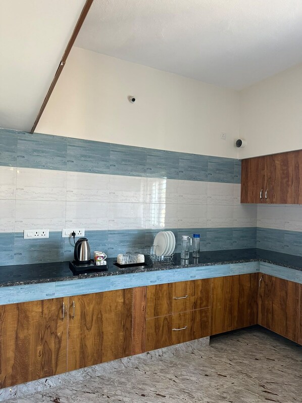 A kitchen with wooden cabinets, a granite countertop, and a backsplash with blue and white tiles.