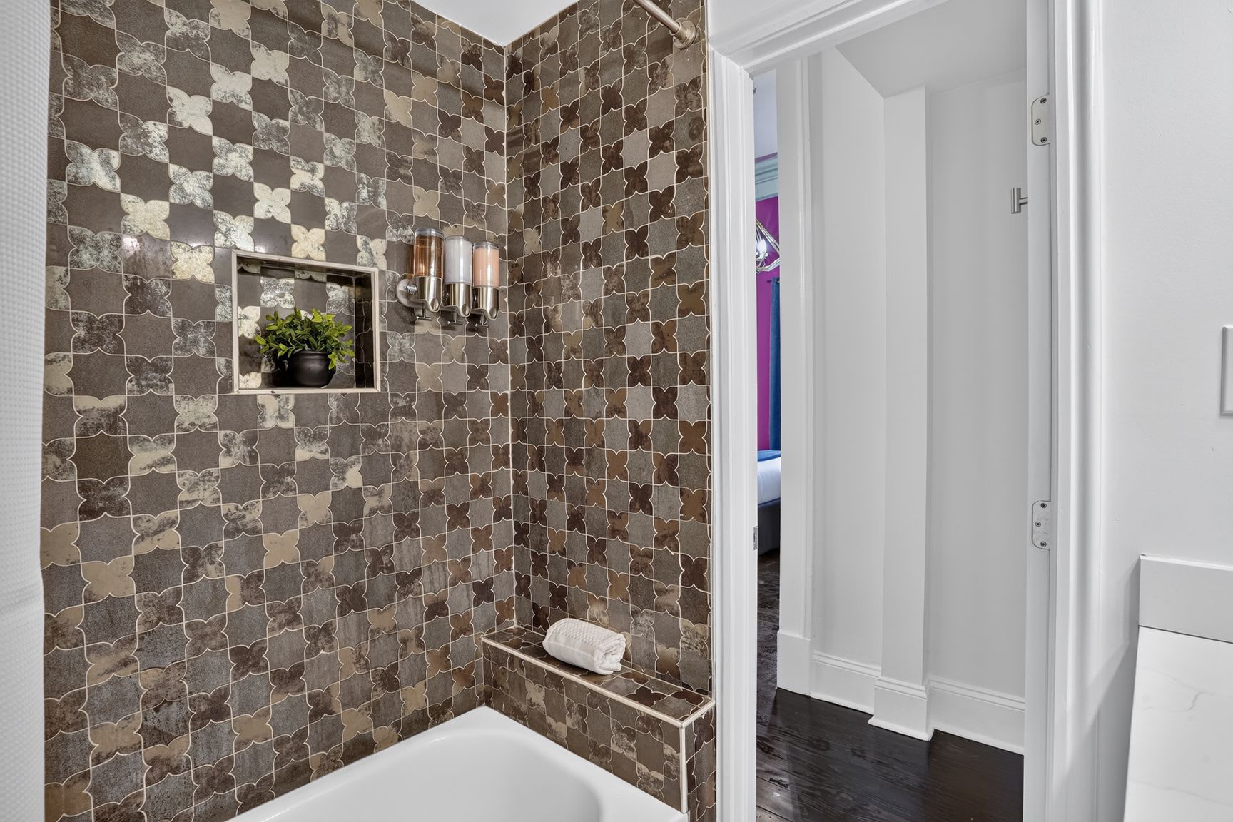 A bathroom with a shower, a towel rack, and a mirror.