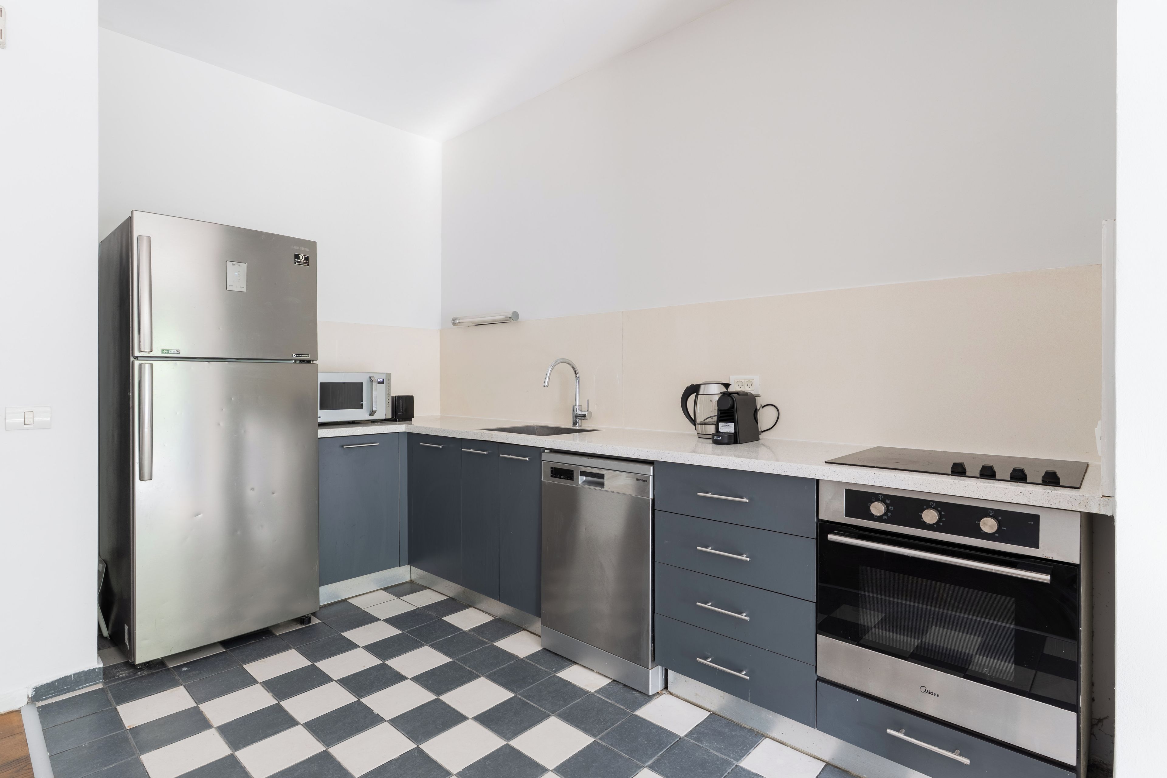 A modern kitchen with a stainless steel refrigerator, microwave, dishwasher, and oven.