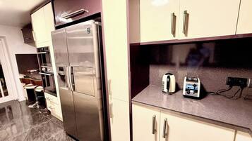 Une cuisine moderne dotée d’appareils électroménagers en acier inoxydable, d’un four encastré et d’un grille-pain posé sur le plan de travail.