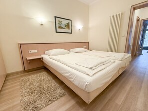 A bedroom with a bed, bedside table, wall-mounted light, and a picture. - Villa Seeadler 615 (Binz)