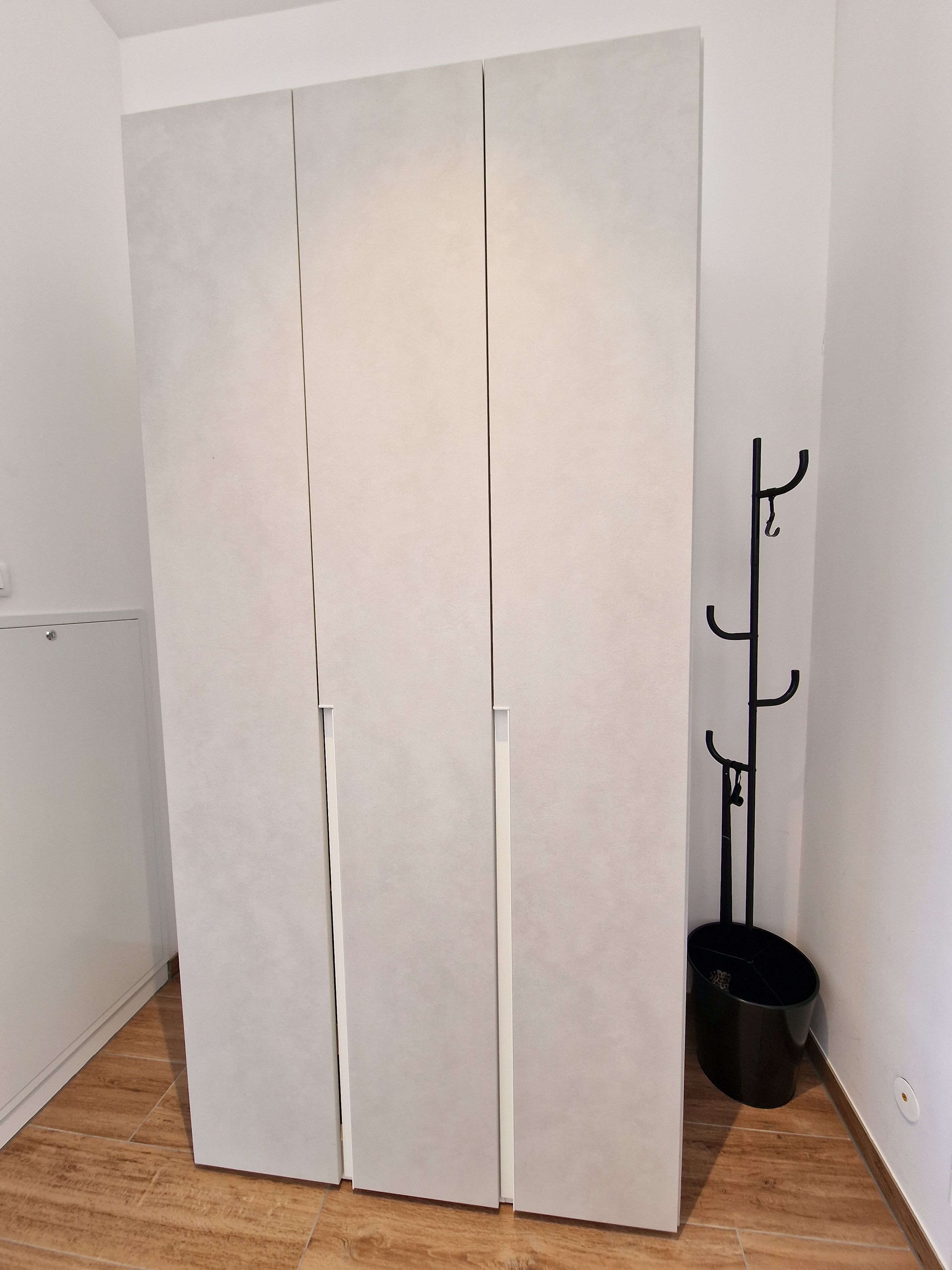 Een gesloten kast met een kapstok ernaast.