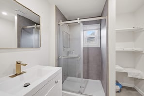 A bathroom with a white sink, a mirror, a shower enclosure, and a towel rack. - Historic Wardensville Home w Mountain Views (Wardensville)