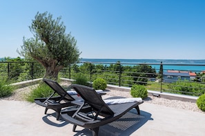 Ein Balkon mit Korbsesseln und Meerblick.