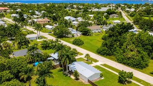 A residential area with houses, green lawns, and a clear view of the ocean. - The McKenzie House (Punta Gorda)