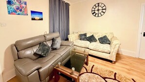 Ein Wohnzimmer mit einer Couch, einem Couchtisch und einer Wanduhr.