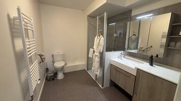 Un baño moderno con inodoro, ducha y tocador.