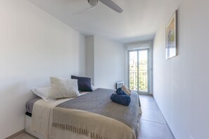 A bedroom with a bed, pillows, a ceiling fan, and a window with a view. - Masade - cocon avec piscine partagée (Trans-en-Provence)