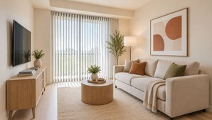 A modern living room with a sofa, coffee table, TV, and artwork. - Toronto Five Eight Suites (Toronto)