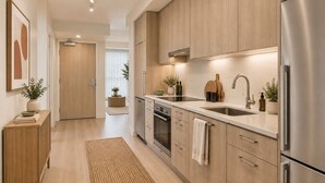 A modern kitchen with wooden cabinets, stainless steel appliances, and a central island. - Toronto Five Eight Suites (Toronto)