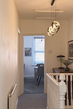 A hallway with a staircase leading to a dining area. - The M4 Escape J26 Free Parking Newport (Newport)