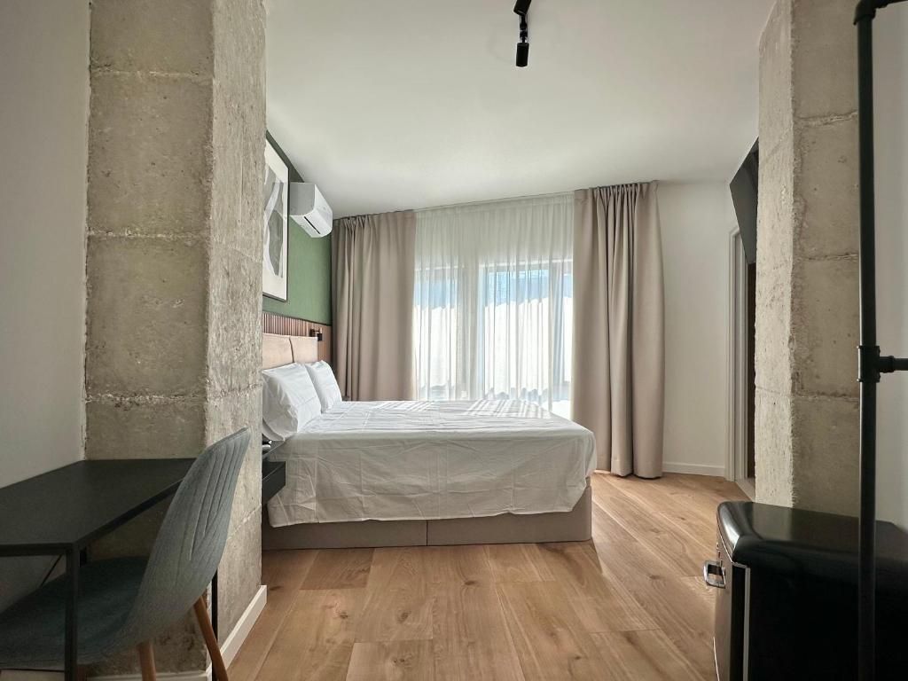 Una camera da letto con un letto, una sedia, una scrivania e un armadio.